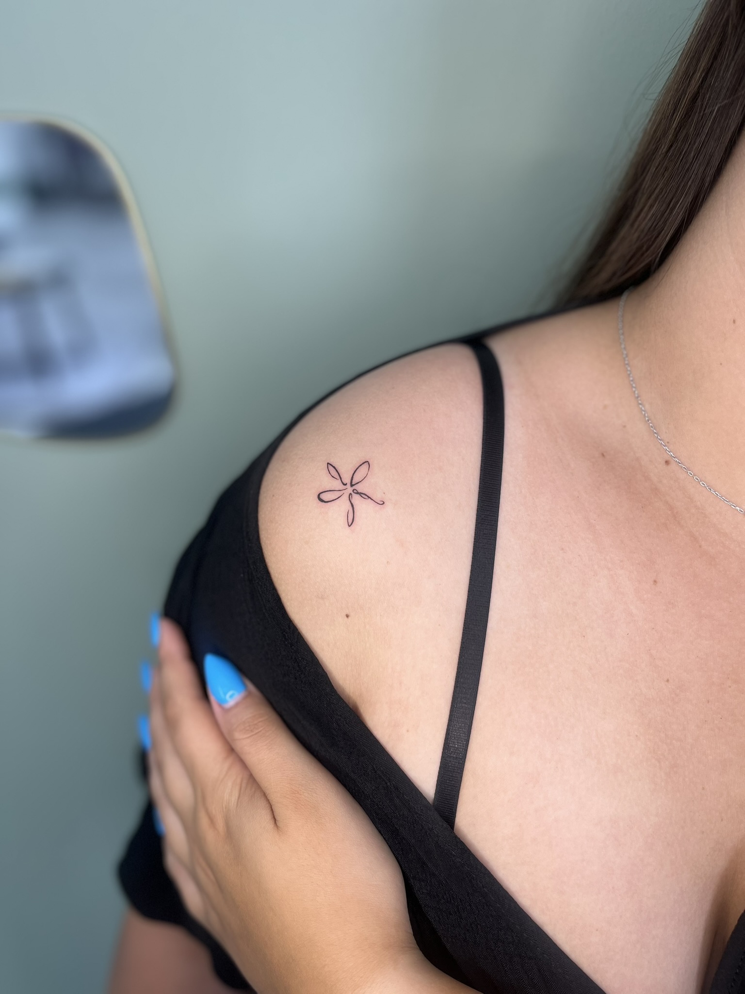 small flower on shoulder tattoo